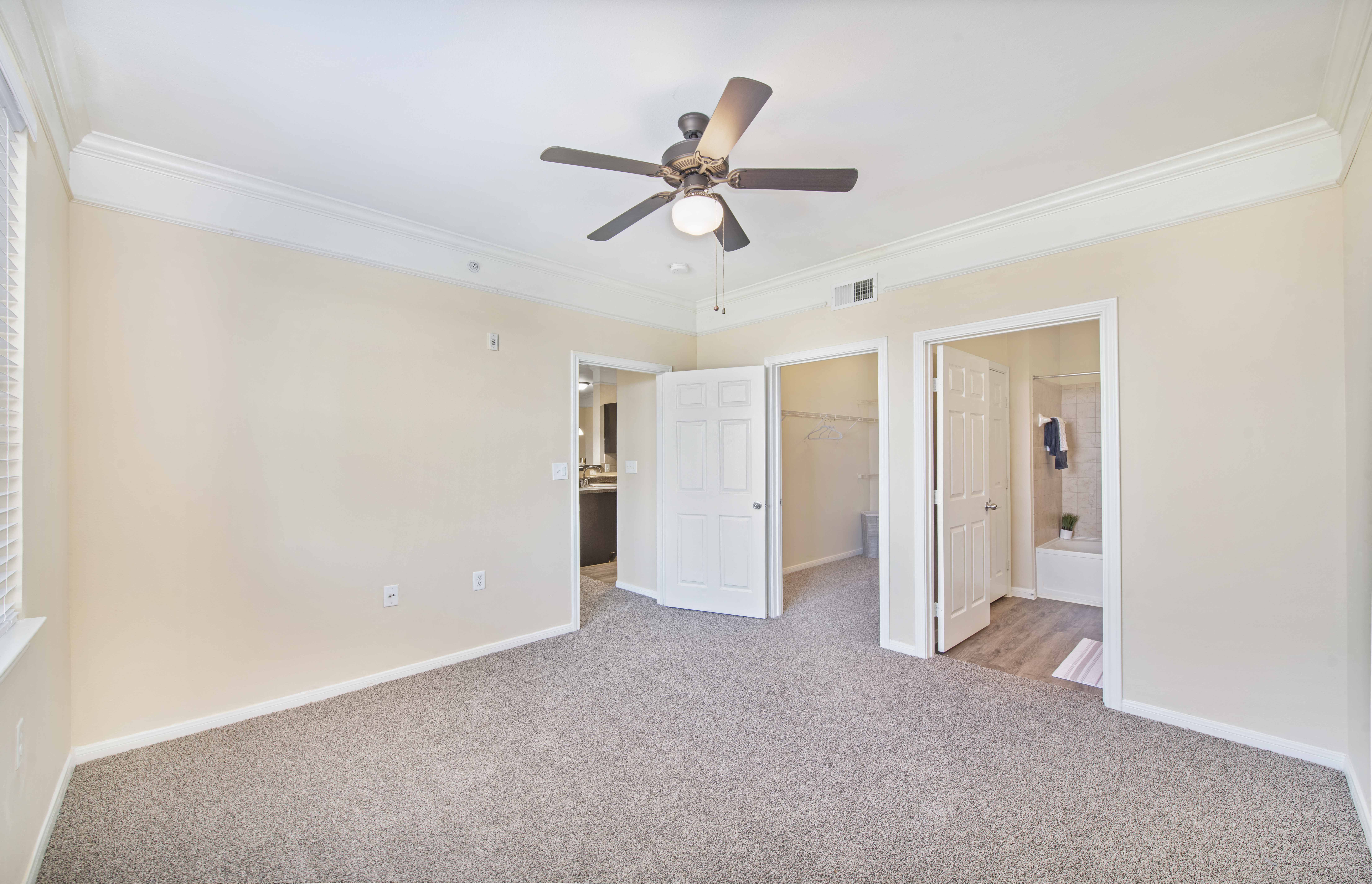 a living room with carpet and a ceiling fan